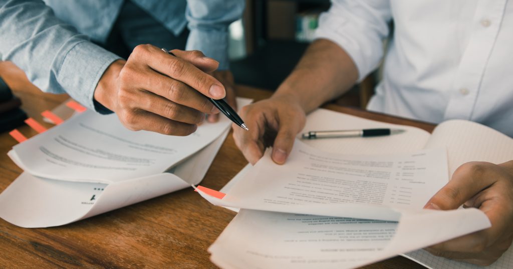 ("Understanding Health Insurance Appeals and Grievances Process") ("A person sitting at a desk reviewing health insurance documents, representing the process of understanding health insurance appeals and grievances.")