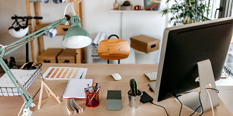Neat and tidy desk or workspace with folders, notebooks, and a computer, illustrating the importance of organization in documentation.